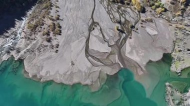 A quadcopter view of Lake Issyk (Almaty Region, Kazakhstan) and the mountain river flowing into it on an autumn morning.