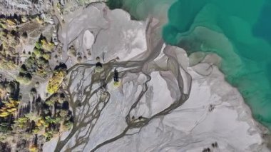 A quadcopter view of Lake Issyk (Almaty Region, Kazakhstan) and the mountain river flowing into it on an autumn morning.