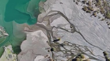 A quadcopter view of Lake Issyk (Almaty Region, Kazakhstan) and the mountain river flowing into it on an autumn morning.