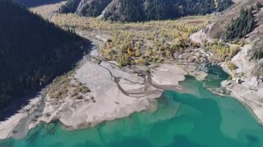 A quadcopter view of Lake Issyk (Almaty Region, Kazakhstan) and the mountain river flowing into it on an autumn morning.