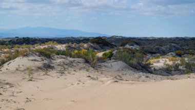 Güneydoğu Kazakistan 'daki Almaty bölgesinin çöl bölgesinde kum tepesi ve bulutlu bir gökyüzü..