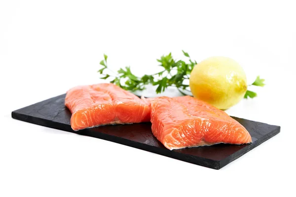 新鮮な魚の切り身パセリとレモンとスレート 白の背景に隔離された — ストック写真