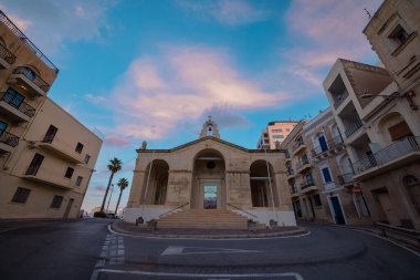 Bugibba şehrindeki Aziz Paul Batık Kilisesi güzel bir akşamda Malta 'da. Alacakaranlıkta kavşağın ortasında ünlü bir kilise..