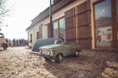 Yeşil renkli çocuklar için eski model bir pedal arabası. Eski oyuncaklar ve küçük çocuklar için ulaşım araçları.