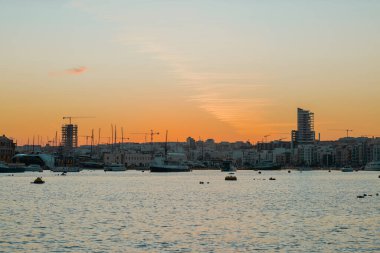 Sonbahar akşamı Malta Adası 'nda Valletta ve Sliema arasındaki Il-gzira rıhtımının manzarası..