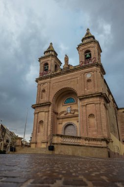 Yağmurlu bir günde Marsaxlokk şehrindeki Santwarju tal-Madonna ta 'Pompei Kilisesi. Yerde yansımalar görülüyor..