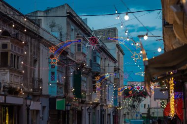 Malta 'da balkon ve Noel' den önce gökyüzünü aydınlatan bir sürü Noel süsleri ve ışıkları olan bir sokak.