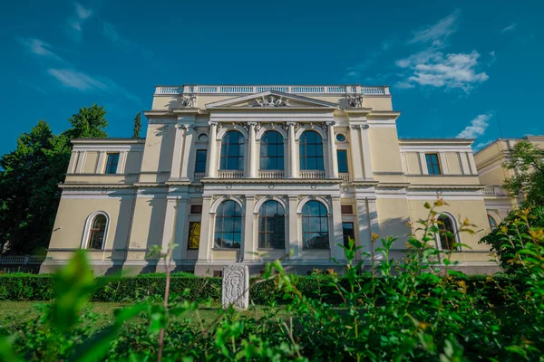 stock image Front facade of national museum of bosnia and herzegovina on a summer day hiding behind some greenery.