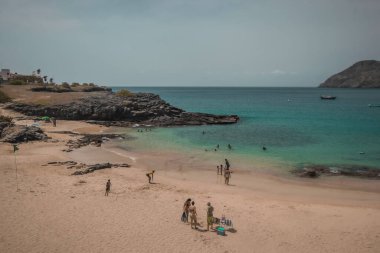 Cabo Verde adalarındaki Santiago adasındaki Pucturesque sahilinde, arka planda bazı ağaçlar ve evler var..