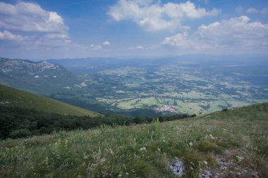Nanos tepesinden veya platodan aşağıdaki postojna vadisine doğru bak. Gökyüzünde bazı bulutlar görünür..