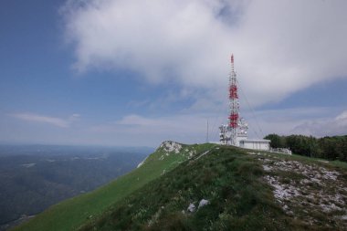 Nanos tepesinden veya platodan yukarıdaki anten işaretçilerine doğru bak. Bazı bulutlar gökyüzünde görünür. Yüksek antenler, 5 gramlık radyo ve televizyon izlendi.