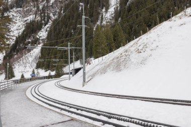 Narrow gauge cog railway above Wengen on a winter day with snow. Empty tracks of train station Allmend.