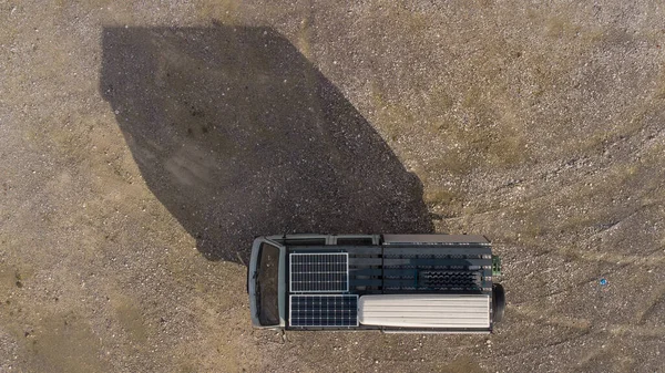 Solar panels installed on a RV or camper vehicle. Dual solar collectors on a roof of a van, view from above, drone view.