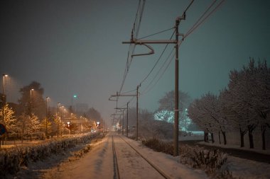 Snow capped railway track or railroad covered with snow during night time.
