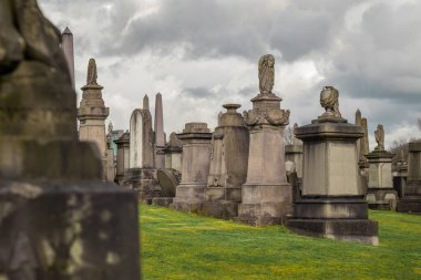 Glasgow nekropolü bulutlu ve güneşli bir günde, Glasgow 'un yukarısındaki bir tepede büyük, resimli bir mezarlık.