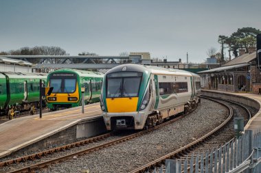 İrlanda 'daki Drogheda Macbride tren istasyonunda, Dublin' den Belfast 'a giden bir hatta. Güneşli bir günde tren ve peronlar geçiyor..