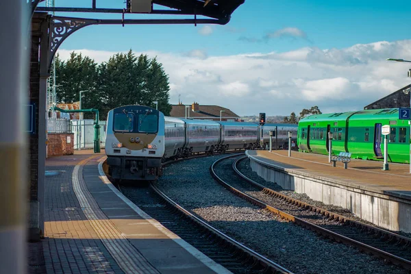 stock image Trains on Drogheda macbride train station in ireland, on a line from Dublin to Belfast. Rail platforms and trains passing by on a sunny day.