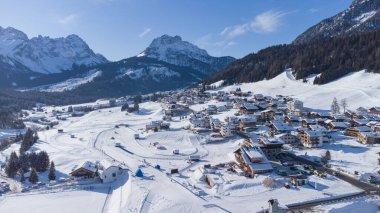 Güneşli bir kış gününde İtalyan Dolomitler 'in Sappada köyünün insansız hava aracı panoraması karla doludur. Dolomitlerin güzel dağlık köyü.