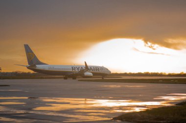 GLASGOW, UK, 24.3.2023: Ryanair Boeing 737 is standing on an apron of international airport with beautiful backlight in early morning. clipart