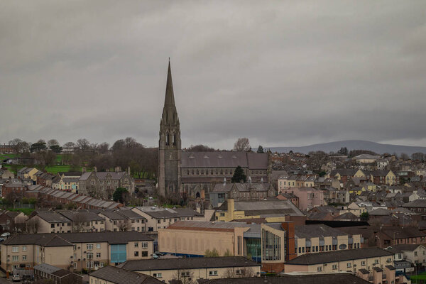 Панорама Дерри или Лондондерри в облачный день с городских стен. Зеленая панорама города, церкви или собора.