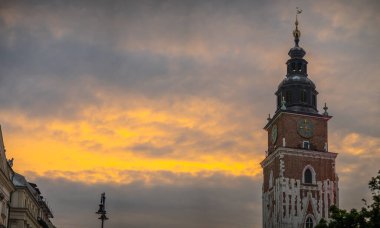 Rynek Glowny 'deki resim kulesi ya da güneşli bir yaz akşamında Krakow' daki ana şehir meydanı. Kule arkasında görünen görkemli gökyüzü.