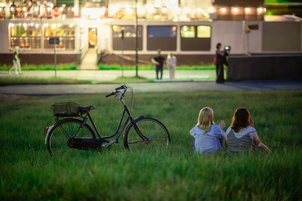 Duas Jovens Mulheres Relaxando Grama Uma Bicicleta Desfrutando Tempo Livre — Fotografia de Stock