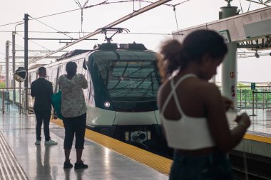 Yeni Panama metro sistemi inşa ediliyor. Havaalanına giden istasyona yeni metro vagonu geliyor. Platformdaki bazı insanlar.