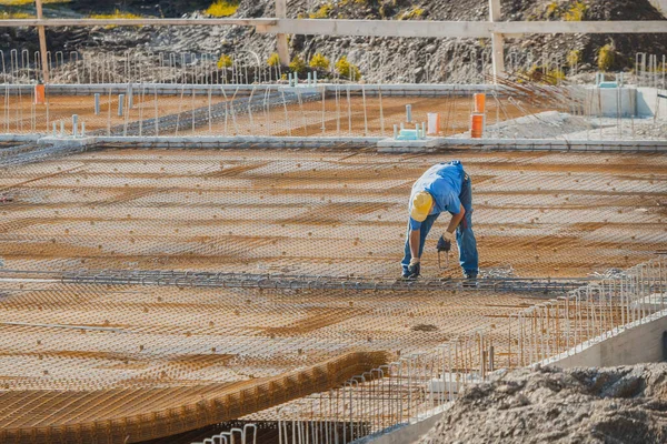 Beton dökülmeden önce inşaat işçilerinin kıskaçları ve çelik demiri ya da armatür çeliği kullanarak inşaat sahasına genel bakış.