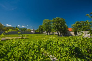 Bosna 'nın Banja Luka kentinde mavi gökyüzü olan bir yaz gününde görünür kulesi olan kale. Görünür yeşil çimenler, kale duvarları ve içinde ağaçlar..