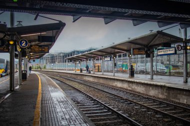 Kuzey İrlanda, Belfast 'taki Great Victoria sokak istasyonunda yolcu platformları. Bulutlu bir günde tren yoluna doğru bakın ve peronu kapatın..