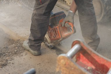 Motorlu asfalt kesici kullanan işçiler ya da asfalt zemini kesmek için yuvarlak bıçaklı testere kullanan işçiler, bir sorunu çözme ya da yenileme süreci olarak kullanılıyor..