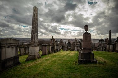 Glasgow nekropolü bulutlu ve güneşli bir günde, Glasgow 'un yukarısındaki bir tepede büyük, resimli bir mezarlık.