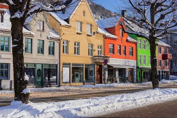 Bergen 'de kışın tipik evler, Bergen sokaklarında soğuk kış günü, yollar karla kaplı ve göl kenarındaki uzun renkli evler.