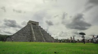Meksika 'daki Yucatan yarımadasındaki muhteşem Chichen itza Piramidinin hızlandırılması veya hızlandırılması. Destansı zaman çizelgesi, bulutlar, bulanık turistler ve yeşil çimenler..