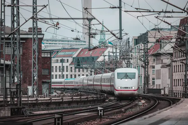 Stock image German high speed train is approaching the station of Berlin Friedrichstrasse station on a cool spring day. Typical houses and TV tower visible in the backgroubd. Train transport in germany.