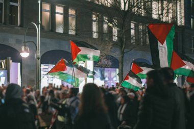 Berlin 'de Filistin yanlısı protestolar. Filistin 'i destekleyen insanlar arasında İsrail' in Gazze 'yi işgaline karşı Filistin bayrakları dalgalanıyor. Avrupa 'da geceleri Filistin yanlısı protestolar