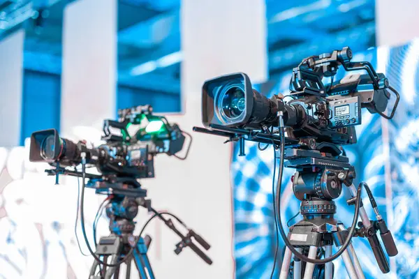 Modern 4K yayın kameraları bir tripoda. Büyük kamera bir konferans ya da etkinlik tribününde canlı yayına hazır, profesyonel video yayını.
