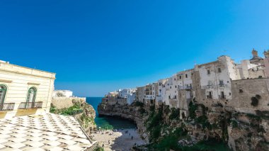 Polignano 'nun geniş manzarası bir kısrak, güneşli bir günde Puglia, İtalya' da güzel bir şehir. Denize görünen kumsal, eski kasabanın yanındaki köprüden bakıyor. Sihirli bahar renkleri