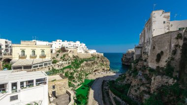 Polignano 'nun geniş manzarası bir kısrak, güneşli bir günde Puglia, İtalya' da güzel bir şehir. Denize görünen kumsal, eski kasabanın yanındaki köprüden bakıyor. Sihirli bahar renkleri