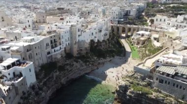Polignano 'nun hava aracı panoraması güneşli bir günde Puglia, İtalya' da güzel bir şehir. Denize görünen kumsal ve yanındaki eski kasaba geliyor..