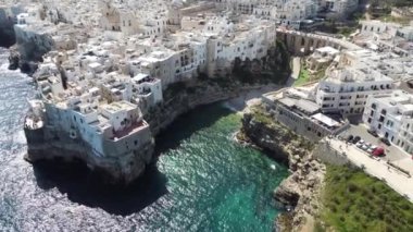 Polignano 'nun hava aracı panoraması güneşli bir günde Puglia, İtalya' da güzel bir şehir. Denize görünen kumsal ve yanındaki eski kasaba geliyor..
