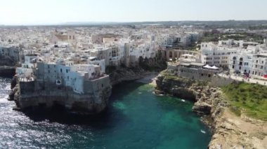 Polignano 'nun hava aracı panoraması güneşli bir günde Puglia, İtalya' da güzel bir şehir. Denize görünen kumsal ve yanındaki eski kasaba geliyor..