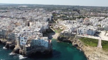 Polignano 'nun hava aracı panoraması güneşli bir günde Puglia, İtalya' da güzel bir şehir. Denize görünen kumsal ve yanındaki eski kasaba geliyor..