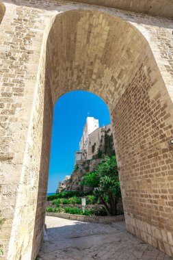 Polignano a Mare 'de kemer köprüsü, şehir kayalıkları arasında plajı olan güzel bir şehir. Güneşli bir bahar gününde İtalya 'da pitoresk bir köyün renkli bir resmi.