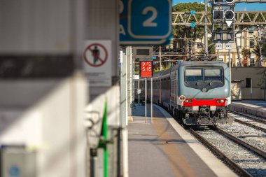 Güney İtalya 'daki Brindisi istasyonuna giden yolcu treni, Puglia. Güneşli bir bahar gününde 2 numaralı perona yaklaşan tren..