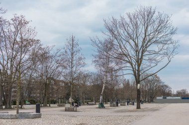 Berlin Duvarı 'nın kalıntıları Berlin' in merkezinde Mauer Parkı 'nda ya da duvardaki Park' ta. Etrafı çıplak ağaçlarla çevrili ilkbahar manzarası. Bulutlu hava.