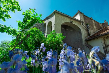 Vinagora 'daki kilise, Hırvat Zagorje, güneşli bir günde. Tepedeki Meryem Ana Kilisesi, dışarıdaki beton atari salonlarının manzarası ve birkaç çiçek.