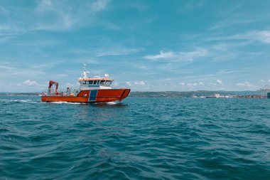 Slovenya Koper körfezinde sahil güvenlik ya da kurtarma botu. Turuncu gövdesi ve beyaz üst yapısı olan tipik bir kurtarma botu. Koper limanında tekne müşterisi.