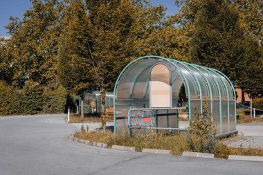 Marketin önündeki alışveriş arabaları için terk edilmiş garajlar. Şehir merkezindeki metal alışveriş arabaları için boş bir garaj.