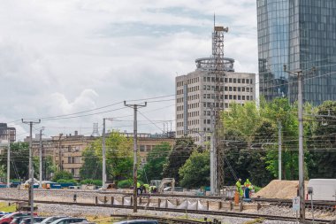 Ljubljana 'nın banliyö bölgesinde demiryolu hattında çalışıyorum. Görünür iş treniyle tren raylarının yenilenmesi. Arka planda şehrin ufuk çizgisi